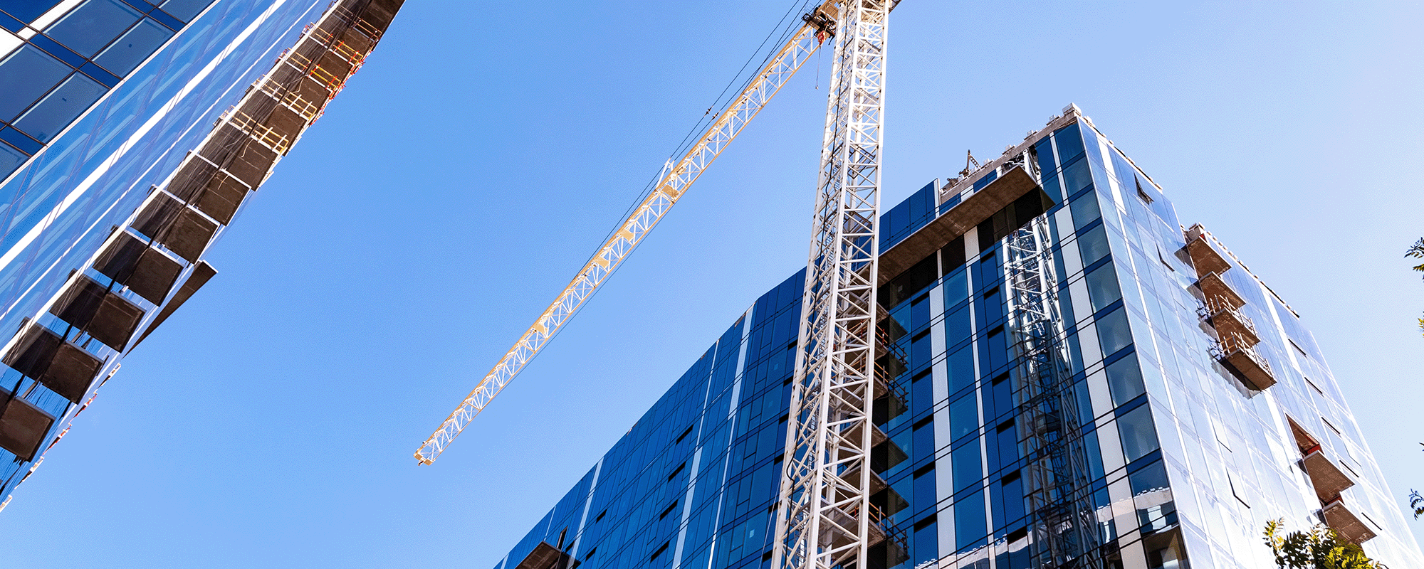 Large crane next to skyscraper at a construction site